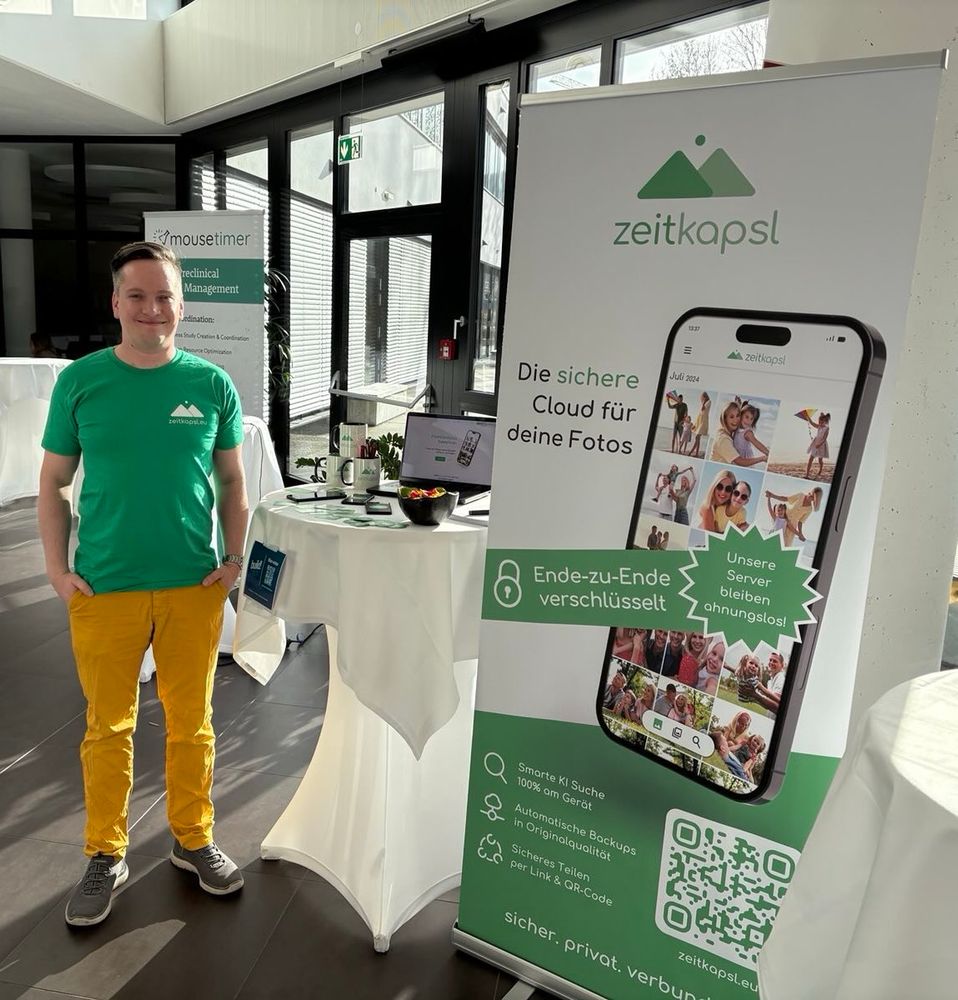 Co-founder Peter standing next to the zeitkapsl rollup banner