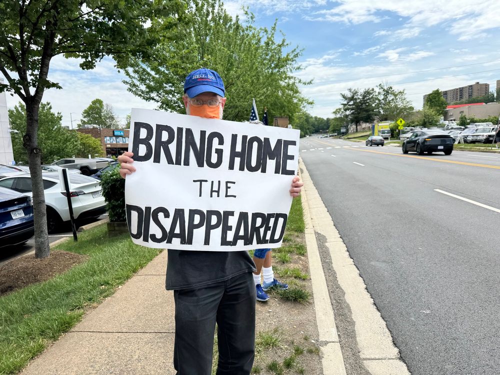 Activist holds sign BRING HOME THE DISAPPEARED