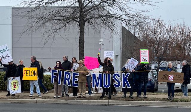 Activists hold sign FIRE MUSK at Tesla Dealership in Virginia 