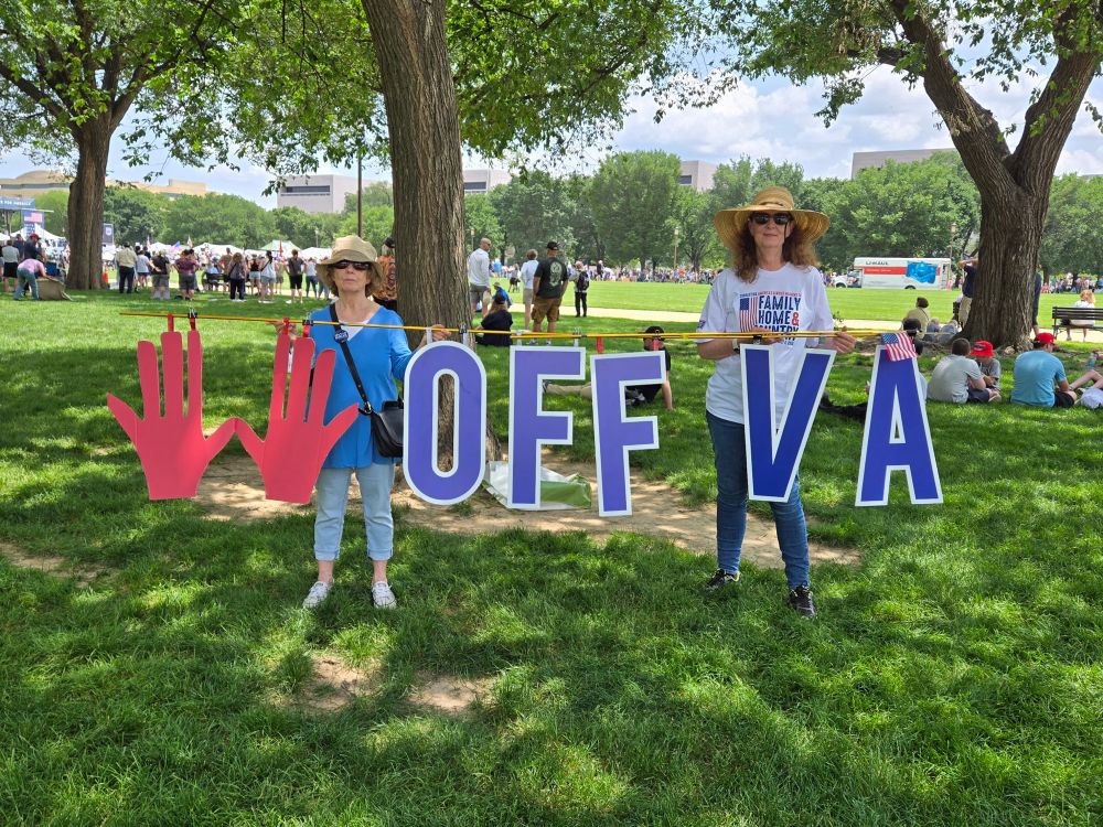 Activists hold sign HANDS OFF VA