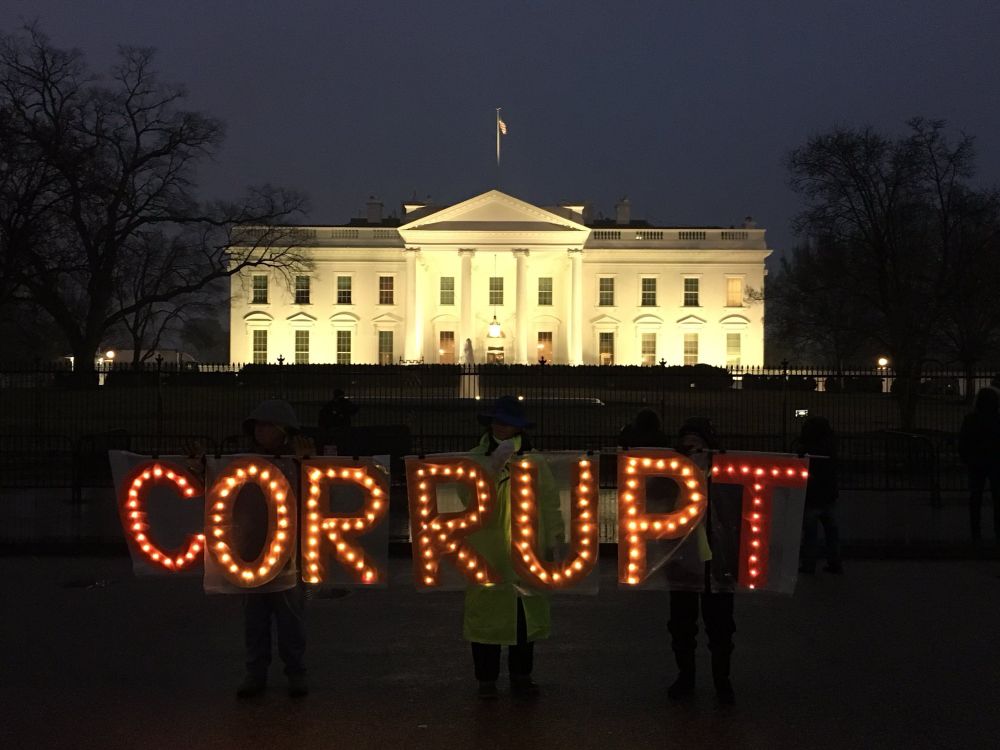 Activists hold sign CORRUPT