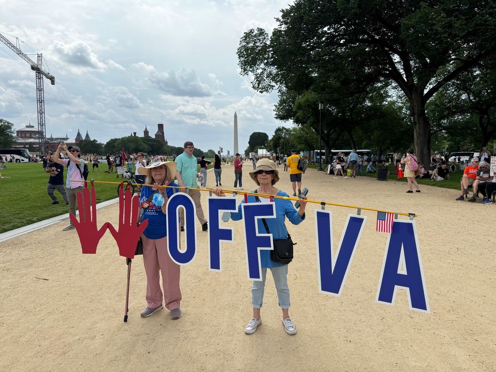 Activists hold sign HANDS OFF VA