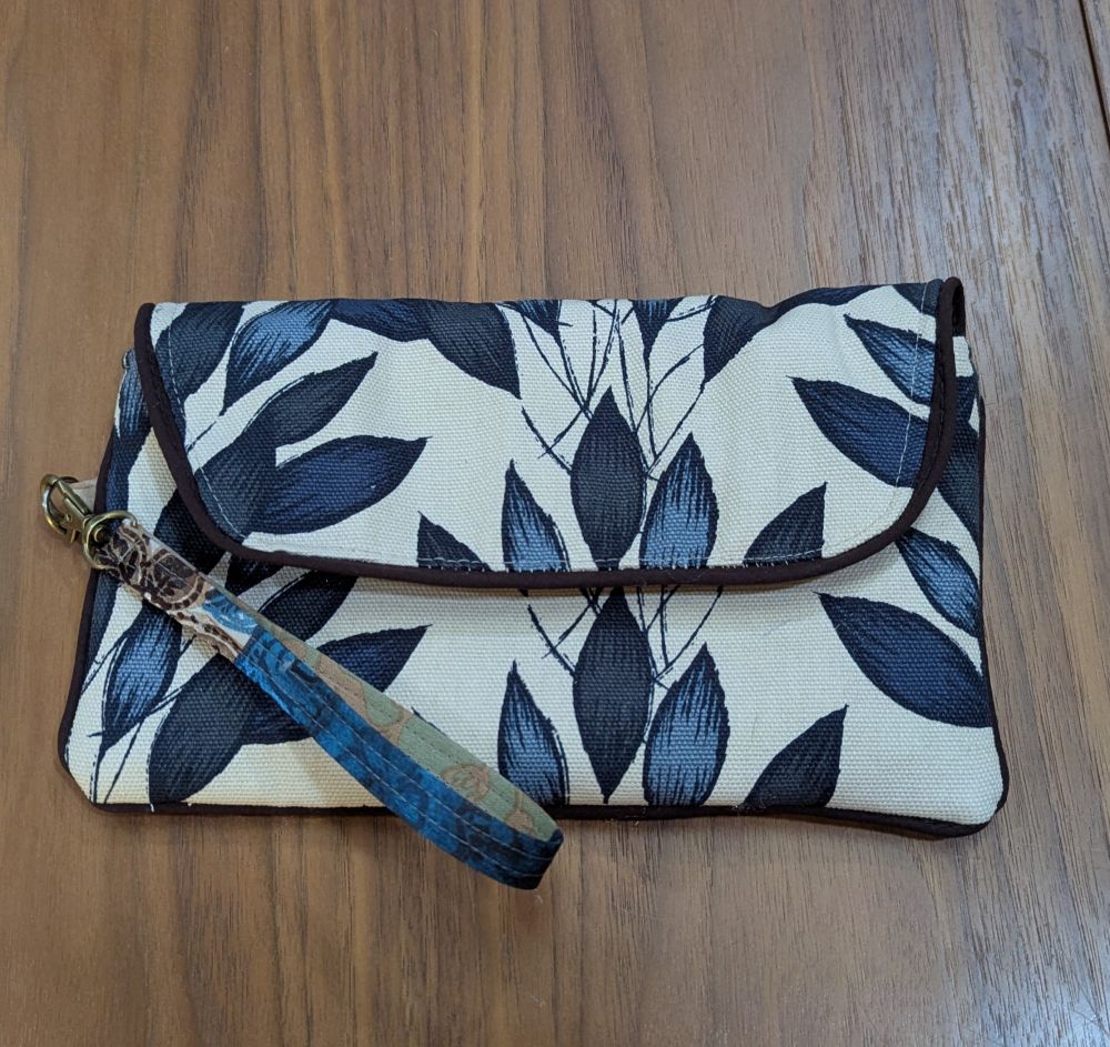 Noodlehead envelope clutch in blue leaf canvas fabric, brown piping and polyester scarf wrist strap