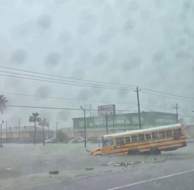 A bus is partly submerged in water.