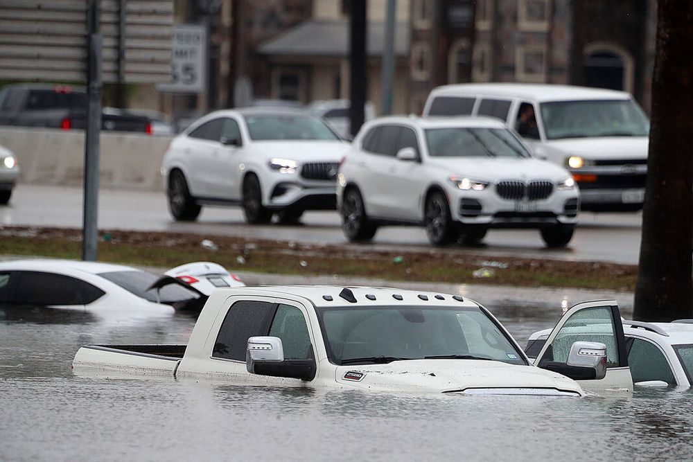 Trucks and cars nearly covered by water.
