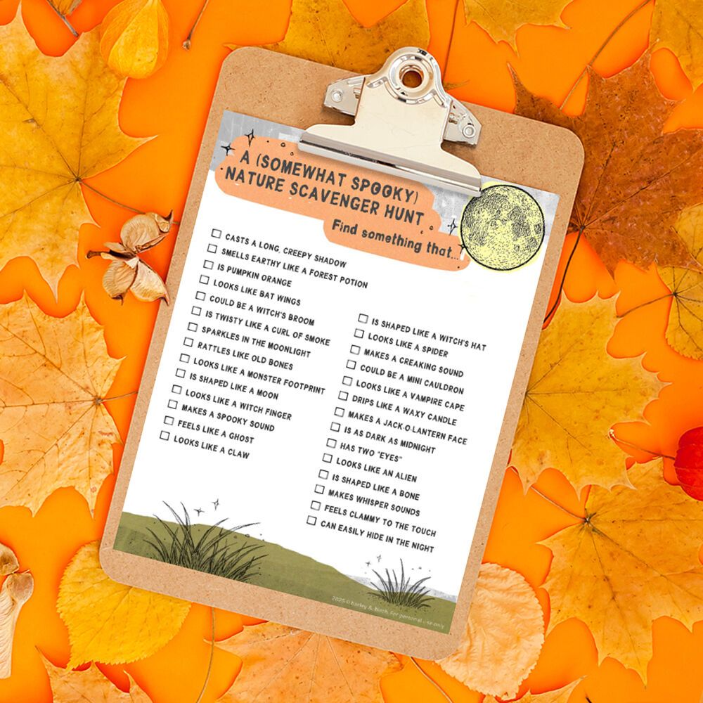 A clipboard holding an outdoor Halloween-themed nature scavenger hunt, sitting on fall leaves on an orange background.