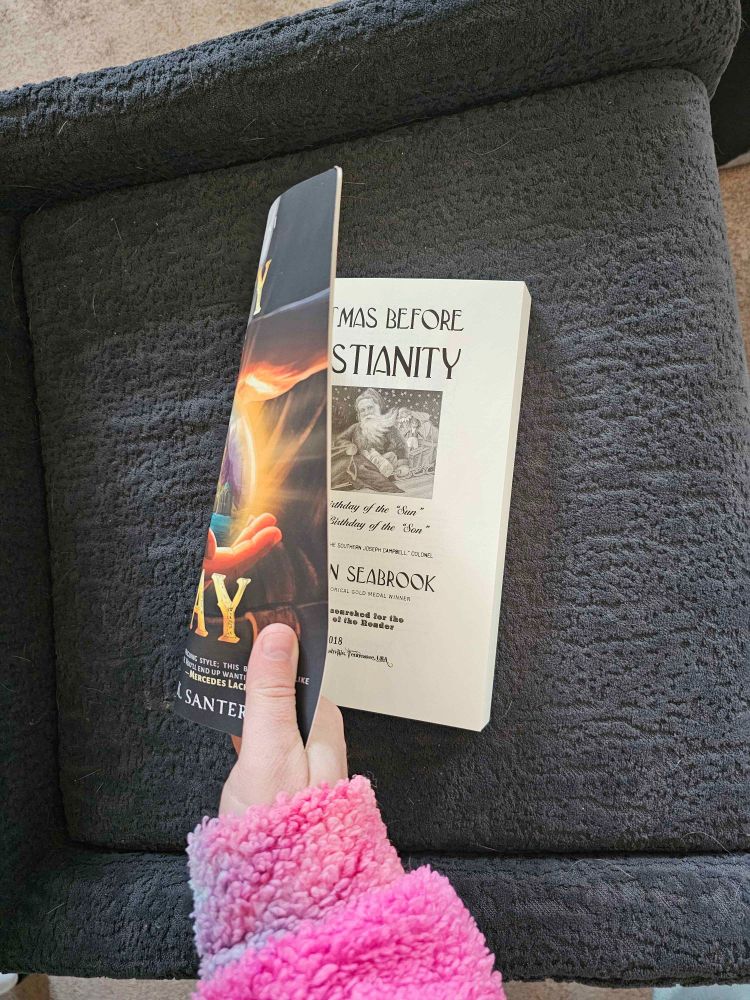 A sliver of the cover of City of Day by October K Santerelli, and the front page of the interior - Christmas before Christianity, printed where the original book should be.