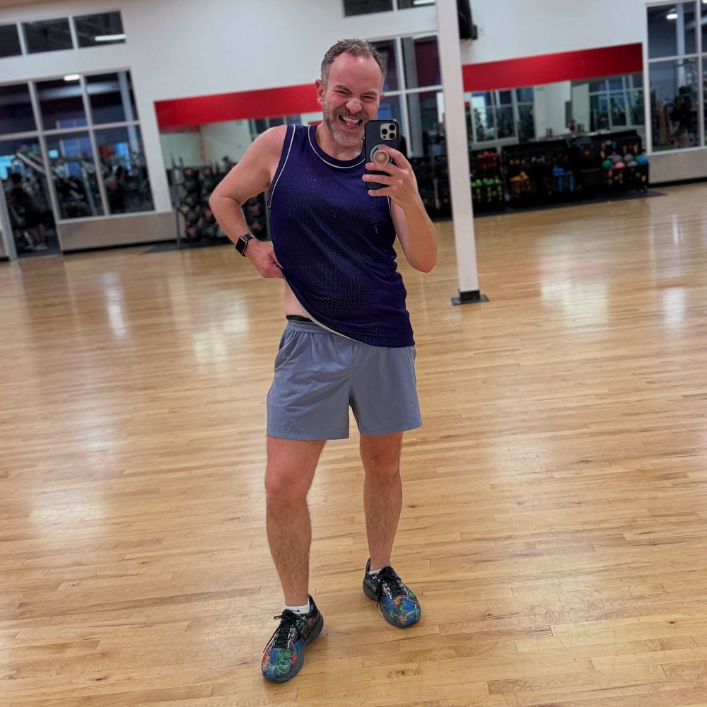 Me after teaching my class in purple shirts and a matching tank. Showing some side stomach and sticking my tongue out 