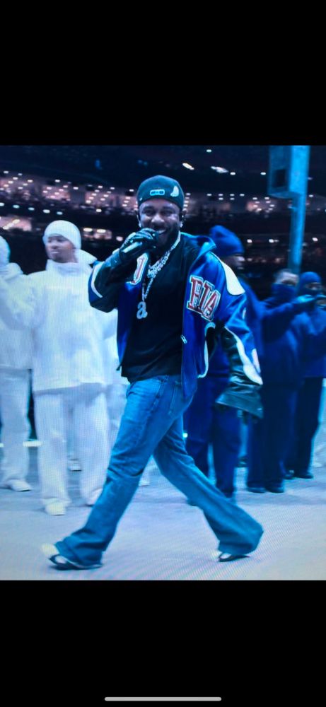 Kendrick Lamar at the super bowl halftime show smiling at the camera