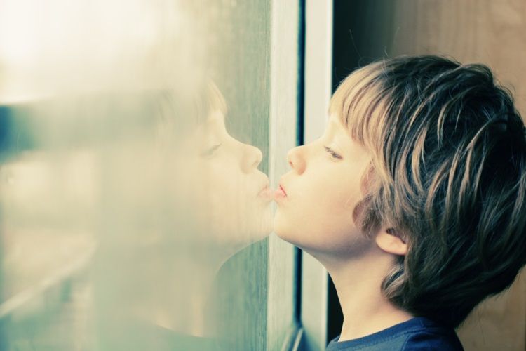 A boy looking out of a window. Photo: Getty Images
