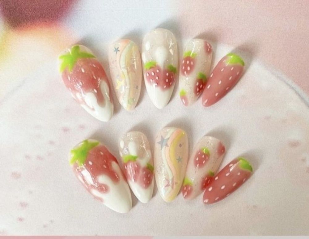 Unhas com desenhos de morango e estrelas