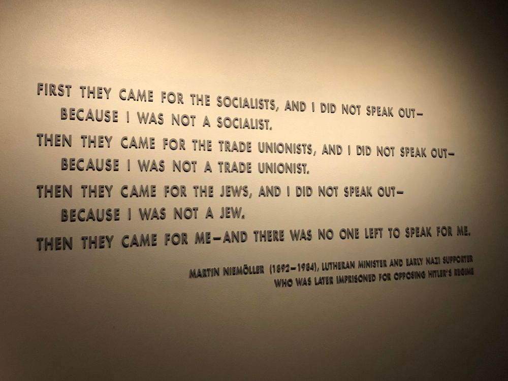 A photo of a quote in gray letters on an off-white wall. It reads:
“First they came for the socialists, and I did not speak out—because I was not a socialist.
Then they came for the trade unionists, and I did not speak out—because I was not a trade unionist.
Then they came for the Jews, and I did not speak out—because I was not a Jew.
Then they came for me—and there was no one left to speak for me.
Martin Niemöller (1892-1984) Lutheran Minister and early Nazi supporter who was later imprisoned for opposing Hitler’s regime.”