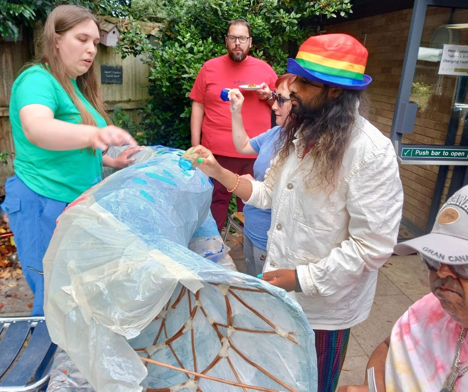 Burhan painting a sculpture in a garden