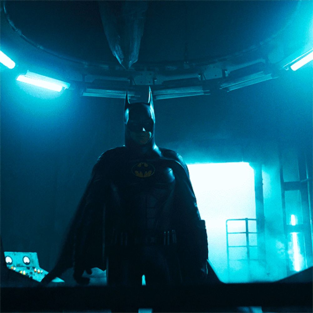 a man in a batman costume is in a dark room