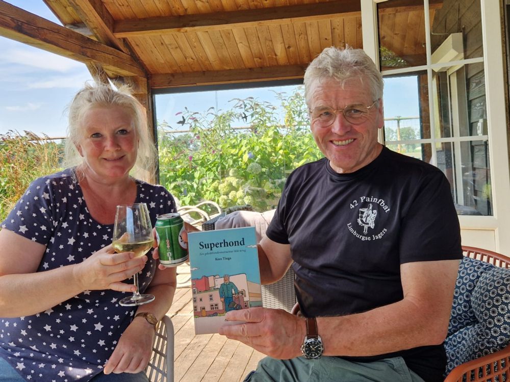 Foto waarop Irma en ik met het boek Superhond in de hand proosten 