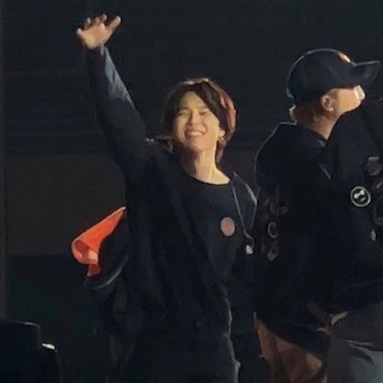 jimin waving at the crowd at a PTD concert