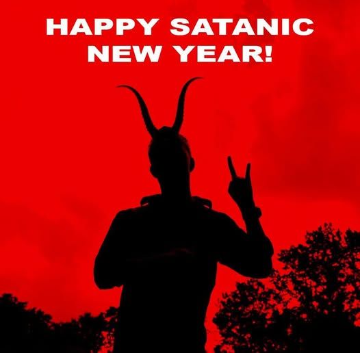 Man in horns silhouetted against red background with white text saying "Happy Satanic New Year!"