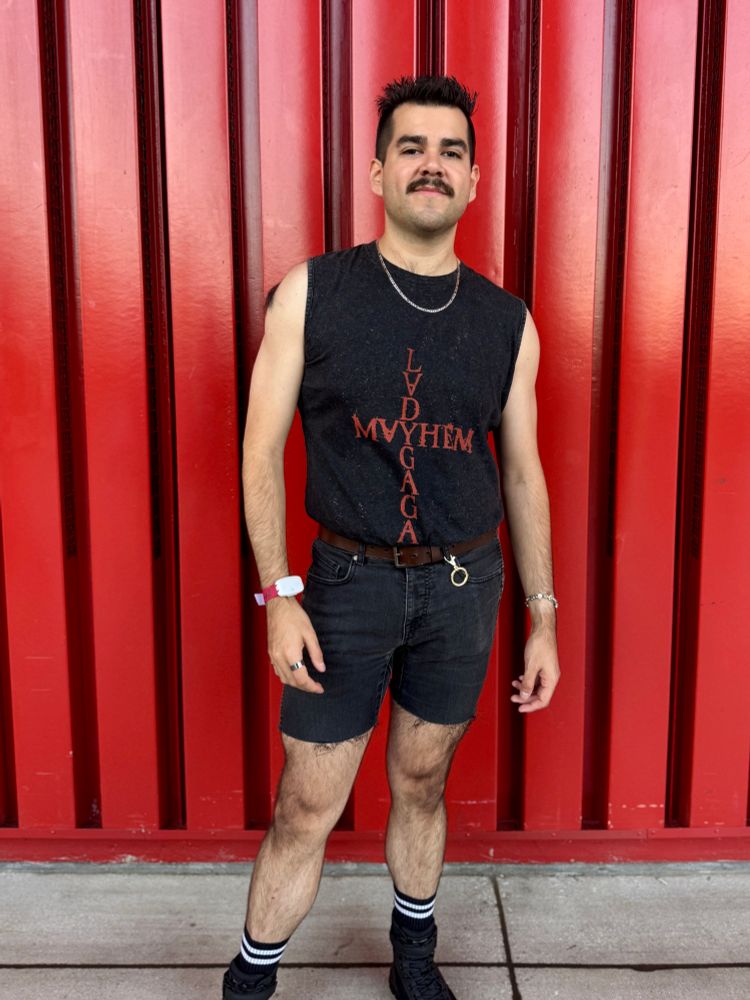 Man posing in front of red wall