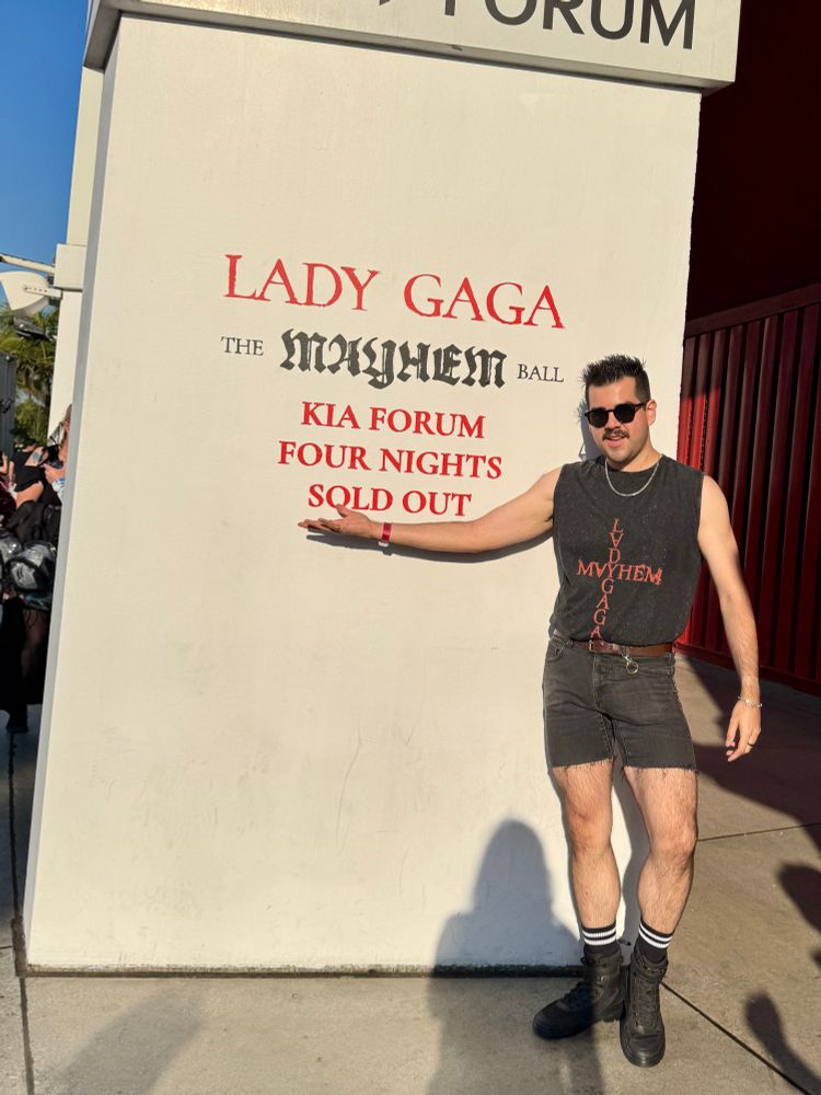 Man posing in front of Mayhem Ball sign