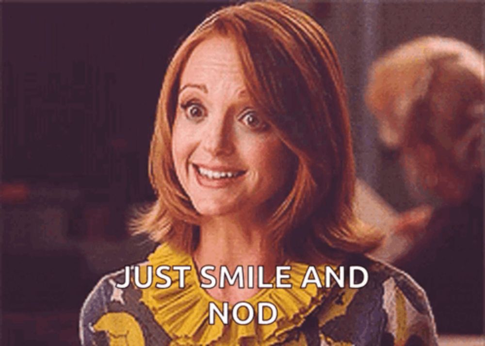 a woman with red hair is smiling and says just smile and nod