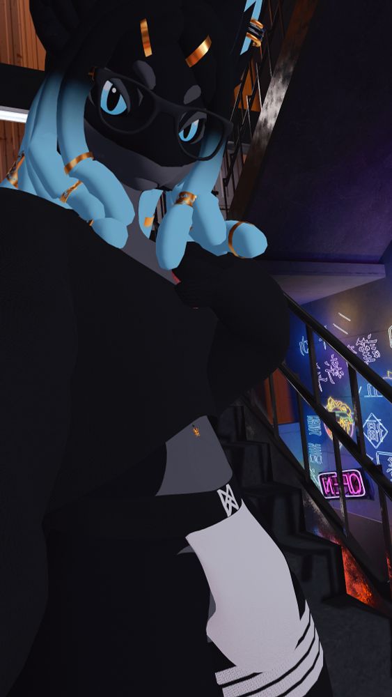A Blue and Black Novabeast with Blue and Black Dreadlocks looks to the camera, wearing various head and face jewelry, a loose crop top, a jockstrap, and stockings. They're in the stairwell to a parking garage, with bright, neon lights in the background