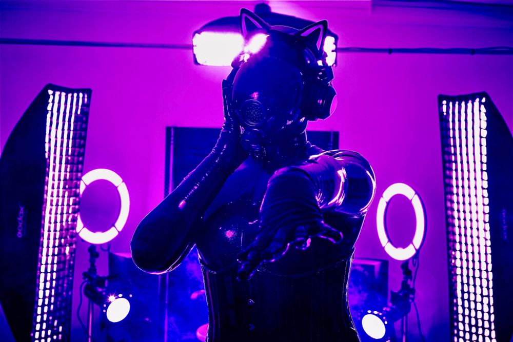 A latex coated drone stands before the viewer with its arm stretched out. It wears an MSA gasmask and insinuates that the view will join it in the Gasmask Monday tradition.