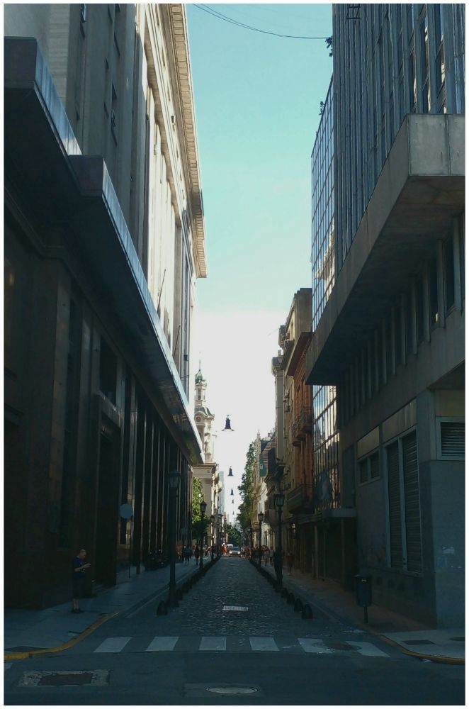 View from a cobblestone in Buen Aires, Argentina between two buildings, in front of Plaza de Mayo