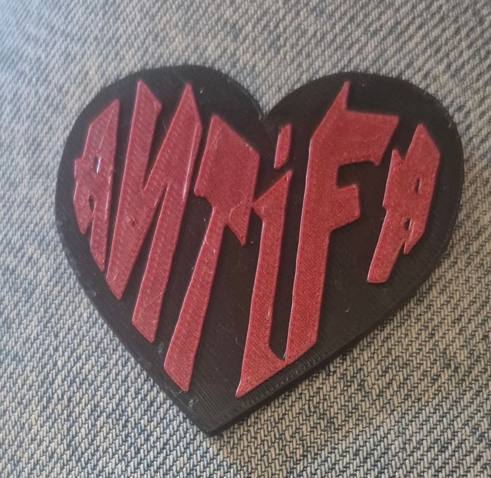 Black heart that says Antifa in red letters.