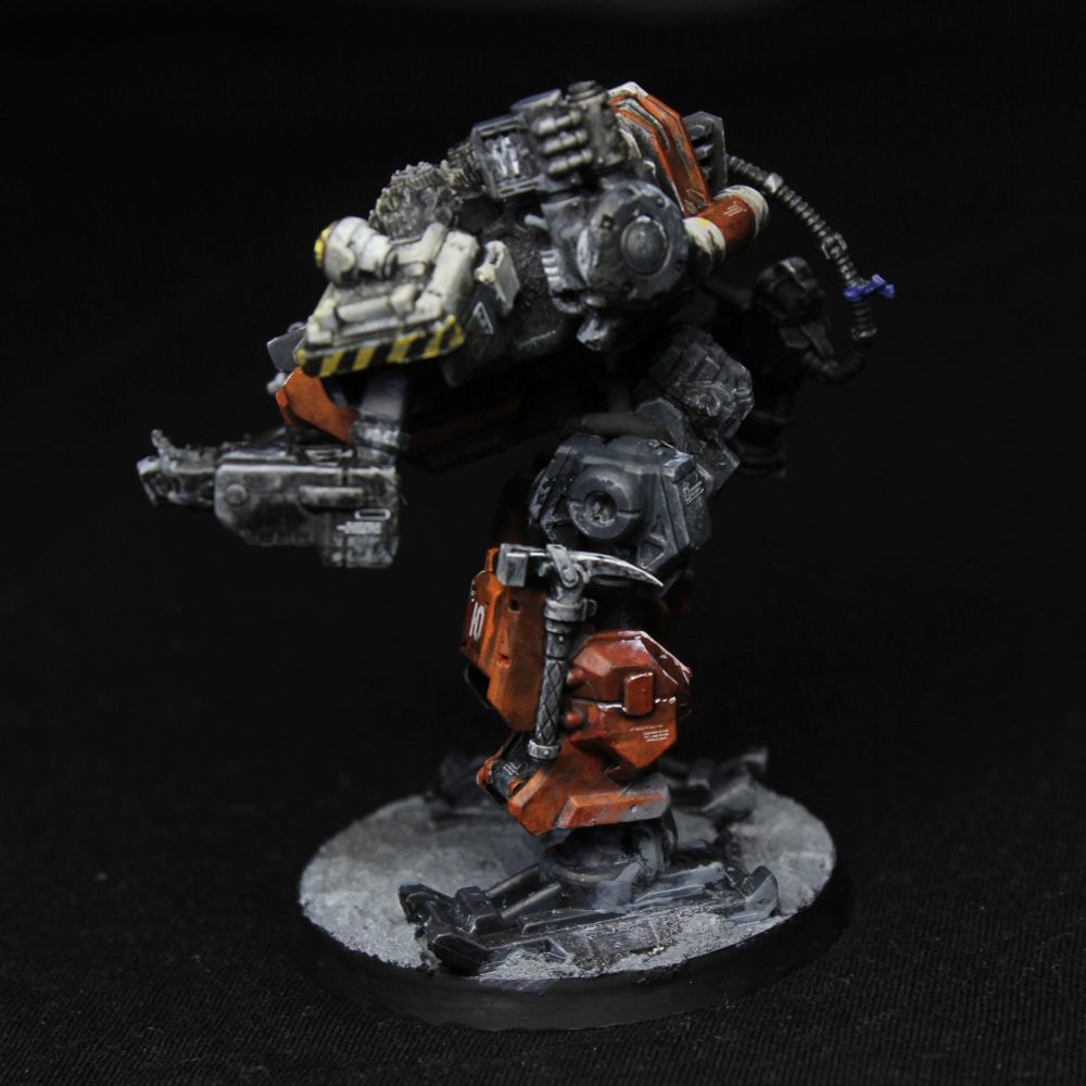 From the other side.
There is a pickaxe-hammer strapped to its knee.