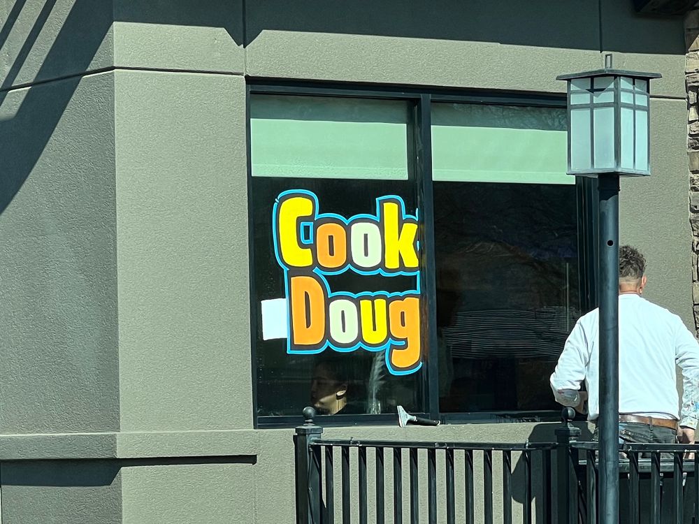 Sign on the front window of a Dairy Queen that says “cook Doug “