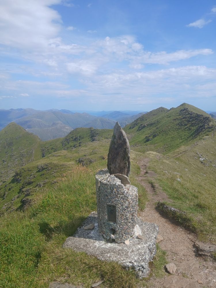The broken base of a trig point near the top of Ladhar Bheinn, with a egg-shaped chunk of stone on it like an award on a plinth.