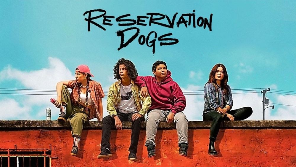 L'affiche de Reservation Dogs, le titre en noir sur un ciel bleu, les 4 personnages principaux assis sur un mur au-dessous