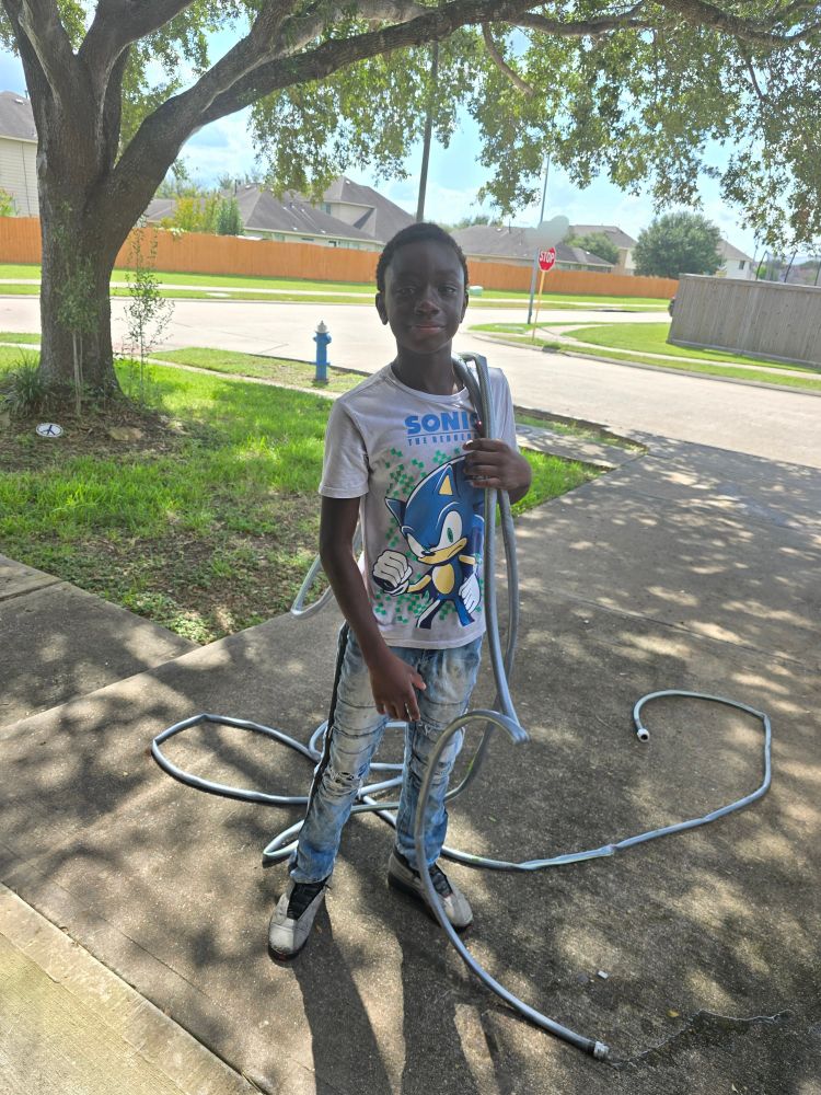 Young boy holding garden hose