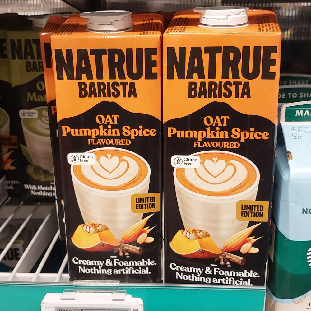 Two one litre containers of pumpkin spice flavoured oat milk, for use in coffee.