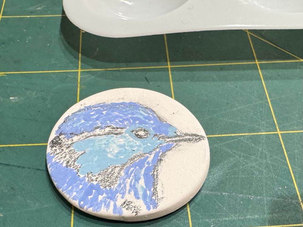 Porcelain ceramic disc with a wren sketched on in pencil and two shades of blue added in little strokes