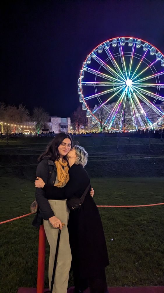 me and Masha hugging, a Ferris wheel in the background