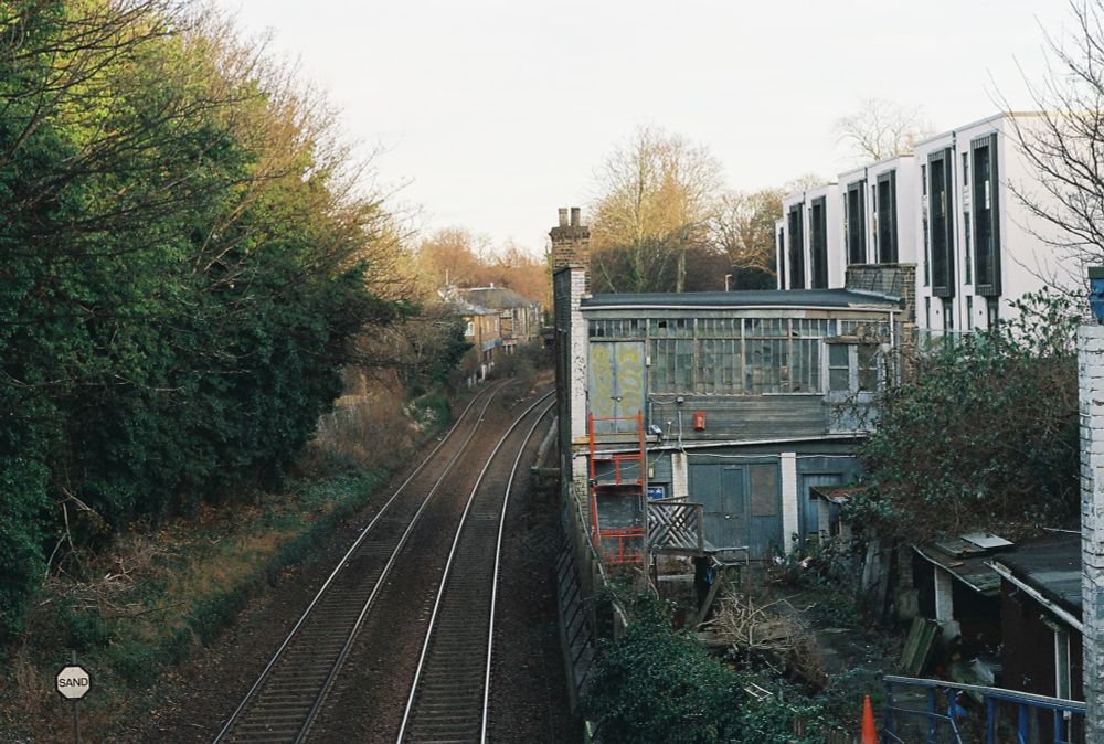 a photo of train tracks and a dilapidated building