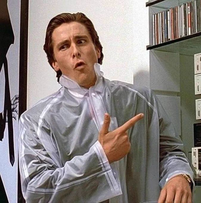 A man with dark hair and wearing a rain smock, pointing to a CD player with a "isn't it flippin' brilliant" look on his face.