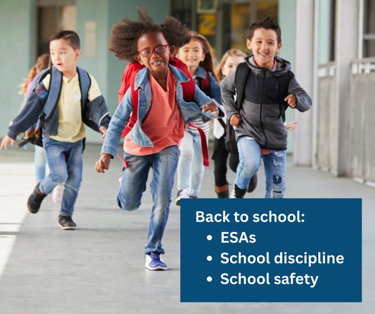 A group of elementary school students wearing backpacks and running in the school hallway. Back to school. ESAs, school discipline, school safety.