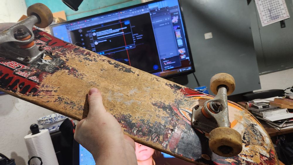 A heavily worn Blind skateboard with Tensor trucks and Darkstar master urethane wheels