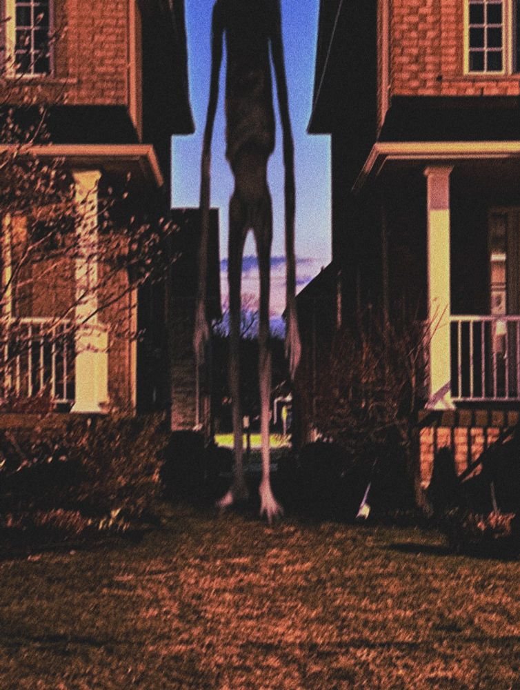 a very tall naked man in between two suburban homes