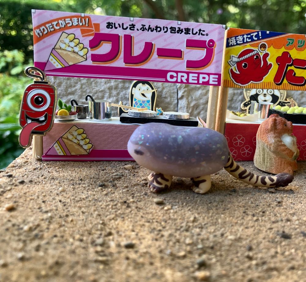 a miniature japanese festival crepe stand staffed by Amabie and Chochin obake. Torakoishi is ordering a crepe