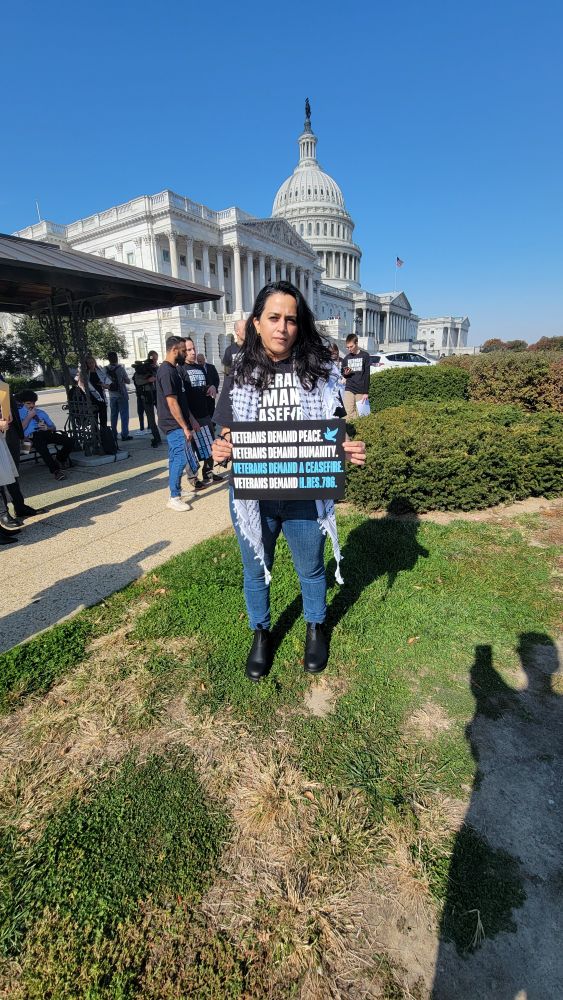 Arti standing in front of the Capitol building in D.C., holding a Veterans Demand A Ceasefire sign. 