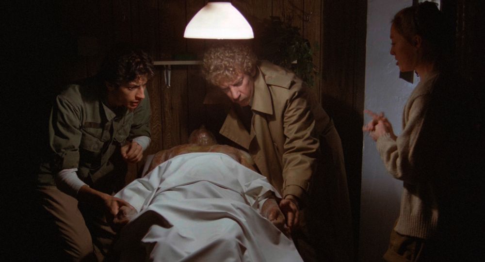 Donald Sutherland, Jeff Goldblum, and Veronica Cartwright inspect a strange body in Invasion of the Body Snatchers (1978).