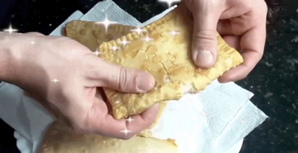 a person is holding a piece of food on a napkin with sparkles coming out of it .