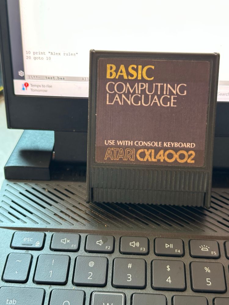 An Atari 400/800 Basic Computing Language cartridge sitting on a modern laptop.