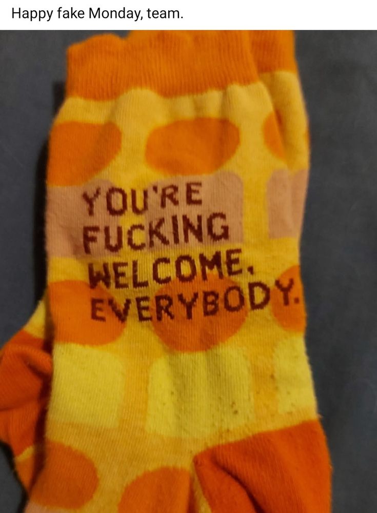 Yellow socks with orange and purple geometric shapes. On the side that you can see, it says, "You're fucking welcome, everybody."