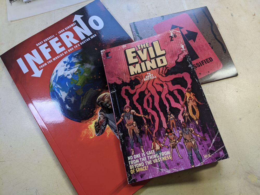 The covers of Cutaway Comics' Inferno graphic novel, paperback copy of The Evil Mind novella, and inverno extras DVD. 