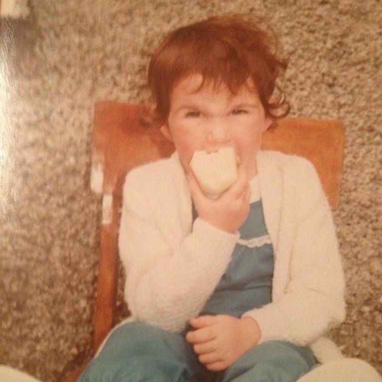 small child eating an apple on a chair 