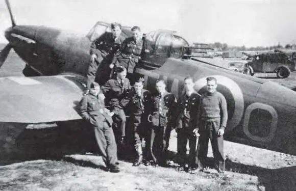 Defiant crews of 141 Squadron, pictured in 1940.
📷 key.aero

(Group of aircrew standing in front of a single-engine turret fighter)